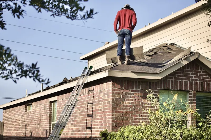 Professional roofer working on a residential roof in Poteau